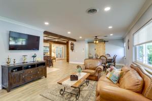 sala de estar con muebles de cuero y TV de pantalla plana en Charming Home with Yard about 5 Mi to Clearwater Beach!, en Clearwater