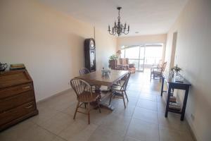 a dining room and living room with a table and chairs at Departamento vista al rio 2 dormitorios, dos baños. Amplio y moderno in Posadas