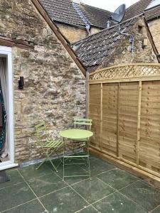 a table and a chair on a patio at Centrally located flat with parking in Tetbury