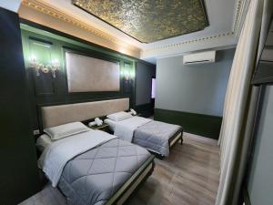 duas camas num quarto com paredes verdes em Hotel Lotus em Tirana