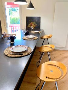 a table with chairs and plates and wine glasses at Guethary superbe appartement centre proche plage in Guéthary