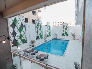 una piscina en un edificio con mesas y sillas en TK Suites, en Hurghada