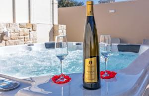 een fles wijn zittend op een tafel met twee wijnglazen bij Konstantinos luxury suite in Koutsourás