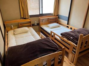 a room with two bunk beds and a window at Guesthouse Matsushiro Walkers in Nagano