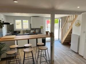a kitchen with a counter and stools in a room at Le nid de Nuits in Nuits-Saint-Georges