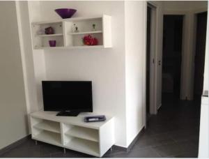 telewizor na białym stojaku w pokoju w obiekcie Chianurré w mieście Partinico