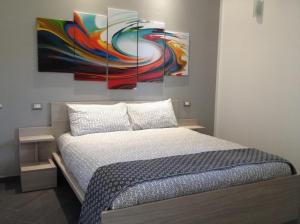 sypialnia z łóżkiem z dwoma obrazami na ścianie w obiekcie Chianurré w mieście Partinico