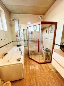 a bathroom with a tub and a glass shower at Apartament Premium Skawina in Skawina