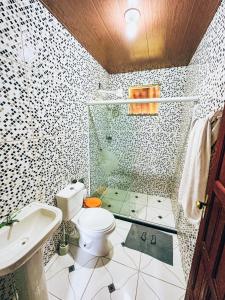 a bathroom with a shower and a toilet and a sink at Pousada Sítio da Floresta in Sana