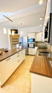 cocina grande con armarios blancos y encimeras de madera en Apartament Premium Skawina, en Skawina