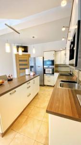 a large kitchen with white cabinets and wooden counter tops at Apartament Premium Skawina in Skawina