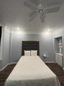 a bedroom with a bed with a ceiling fan at Winsor Hotel in San Francisco