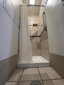 a shower with a white shower curtain in a bathroom at Winsor Hotel in San Francisco