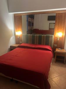 a red bed in a hotel room with two lamps at Terminal guest house 24 in Rome