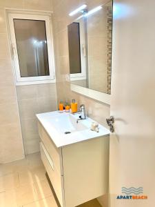 a bathroom with a sink and a mirror at APARTBEACH DIANA Vistas Playa y Climatizado in Salou