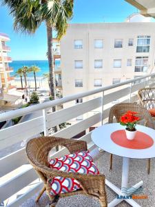 balcone con tavolo, sedie e spiaggia di APARTBEACH DIANA Vistas Playa y Climatizado a Salou