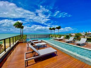 d'une terrasse avec une piscine, des chaises et l'océan. dans l'établissement ARPOAR - Manaíra by PenareiaTurBr, à João Pessoa