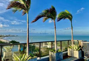 若昂佩索阿的住宿－ARPOAR - Manaíra by PenareiaTurBr，阳台上种植了两棵棕榈树,俯瞰着大海