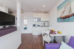 uma cozinha e uma sala de estar com uma mesa e uma televisão em Imperium Central Apartments Zadar em Zadar