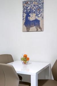 a white table with a bowl of fruit on it at Apartments Villa Bernarda in Šilo
