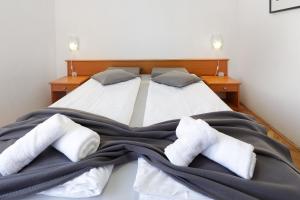 1 dormitorio con 2 camas con mantas y almohadas en Apartments Villa Bernarda, en Šilo