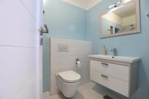 uma casa de banho com um WC, um lavatório e um espelho. em Imperium Central Apartments Zadar em Zadar