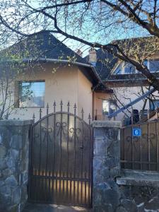 a house with a black iron gate and a house at Casa Roza in Breaza de Sus
