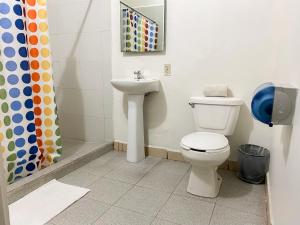 a bathroom with a toilet and a sink at Hotel Amigo Suites in Mexico City