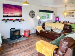 a living room with a couch and a fireplace at The Goat Shed in Hadlow