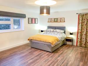 a bedroom with a bed and a wooden floor at The Goat Shed in Hadlow