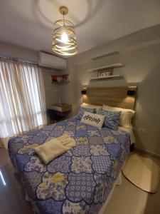 a bedroom with a large bed with a blue quilt at Zafiro Barrio Norte by Citrino Aparts in San Miguel de Tucumán