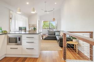 a kitchen and living room with a couch at Lennox Beach Oasis 3 Bedrooms in town in Lennox Head