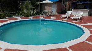 a large blue pool with chairs and a table at Hotel Pacific Blue en Ladrilleros in Buenaventura +28 photos