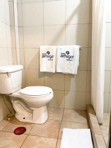 La salle de bains est pourvue de toilettes blanches et de 2 serviettes. dans l'établissement Hotel Amigo Suites, à Mexico