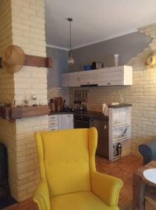 żółte krzesło w salonie z kuchnią w obiekcie Klimatyczny apartament nad jeziorem w Łagowie