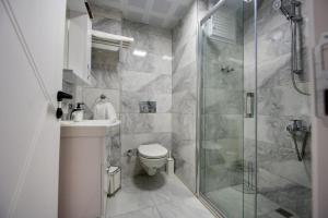 a bathroom with a shower and a toilet and a sink at Bo homes suıt apart in Demre