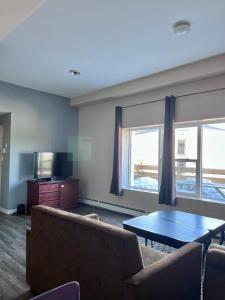 a living room with a couch and a table and a tv at HWY 17 Hotel in Wawa