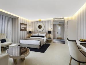Habitación de hotel con cama y sala de estar. en Ramada Hotel & Suites by Wyndham Istanbul- Sisli en Estambul