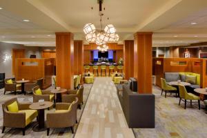 a lobby of a hotel with tables and chairs at Courtyard by Marriott Boston Logan Airport in Boston