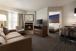 a hotel room with a couch and a bed and a fireplace at Residence Inn El Paso in El Paso