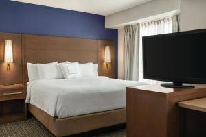 Residence Inn El Paso في الباسو: غرفة فندقية بسرير وتلفزيون بشاشة مسطحة