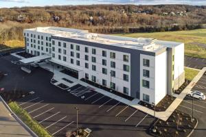 una vista aerea di un grande edificio bianco con parcheggio di Courtyard by Marriott Southington a Southington