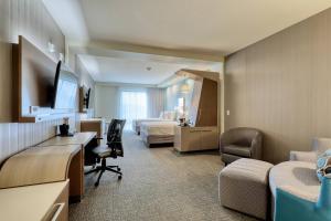 a hotel room with a bed and a desk and a bedroom at Courtyard by Marriott Southington in Southington