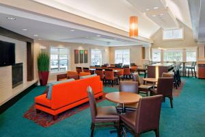 a hotel lobby with tables and chairs and a restaurant at Residence Inn Boston Norwood in Norwood