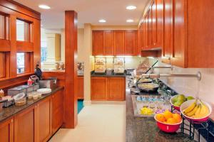 uma grande cozinha com armários de madeira e frutas no balcão em Residence Inn Boston Norwood em Norwood