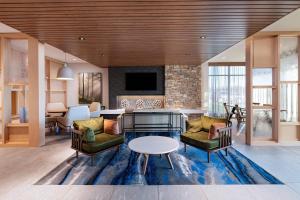 a living room with a table and chairs at Fairfield Inn & Suites by Marriott Oskaloosa in Oskaloosa