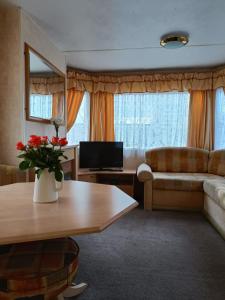 a living room with a couch and a table at Rhosfeillion Static Caravan in Llangefni