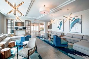 uma sala de estar com cadeiras azuis e sofás em TownePlace Suites by Marriott Miami Airport em Miami