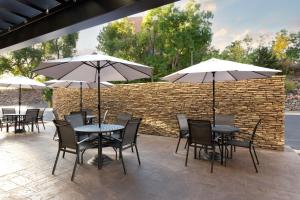 a patio with tables and chairs with umbrellas at Fairfield Inn & Suites by Marriott Denver Southwest/Lakewood in Lakewood