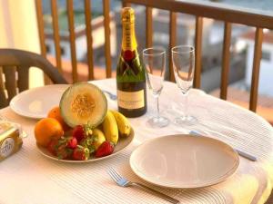 een tafel met een fles wijn en een fruitschaal bij Sunset Seaview La Arena in Puerto de Santiago